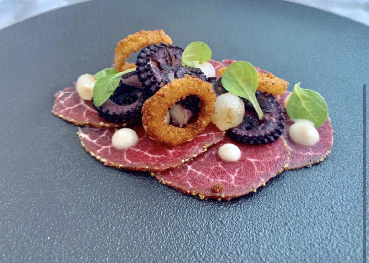 Beef carpaccio with charred octopus, crisp squid rings and onion