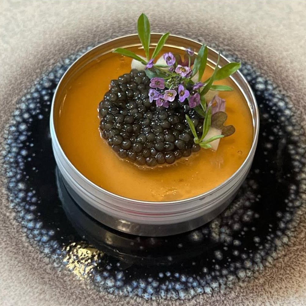 Caviar served over a chilled velouté with edible flowers